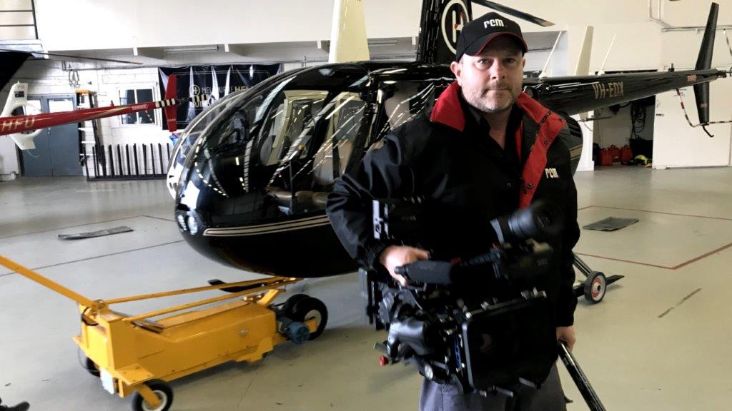 Video Director holding camera at helicopter hanger